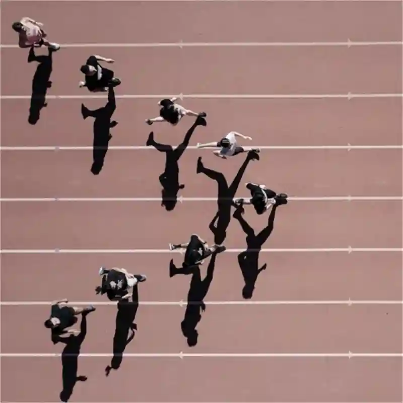 Track runners, running on a track, in a V formation.