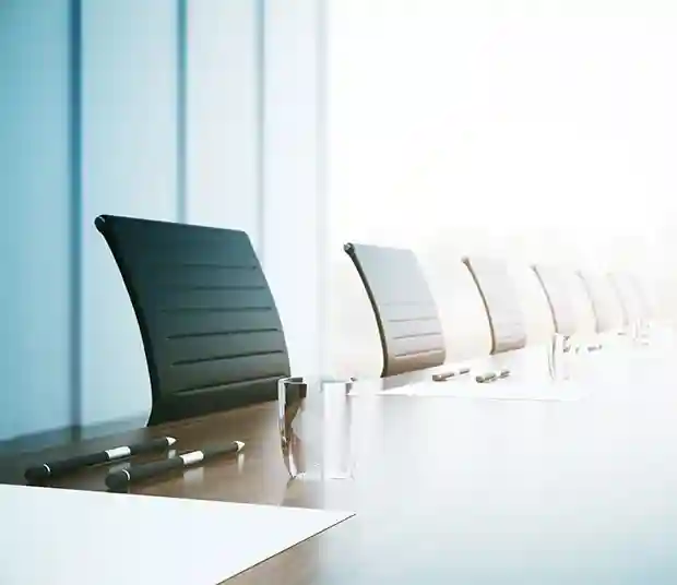 empty conference table set with pens and paper