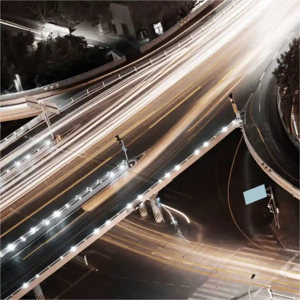 Car lights in a busy intersection at night.