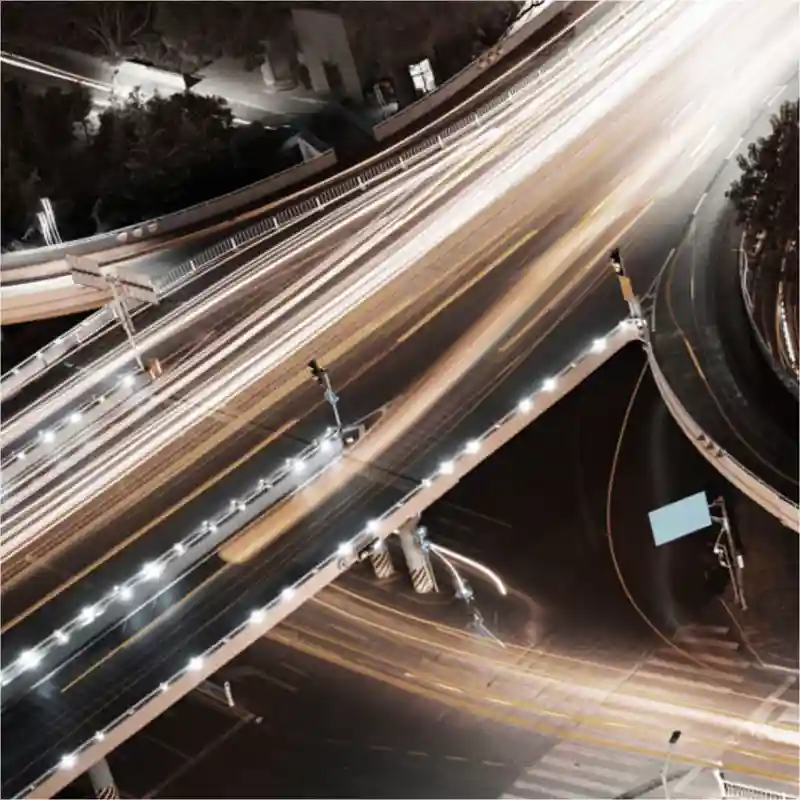 Car lights in a busy intersection at night.