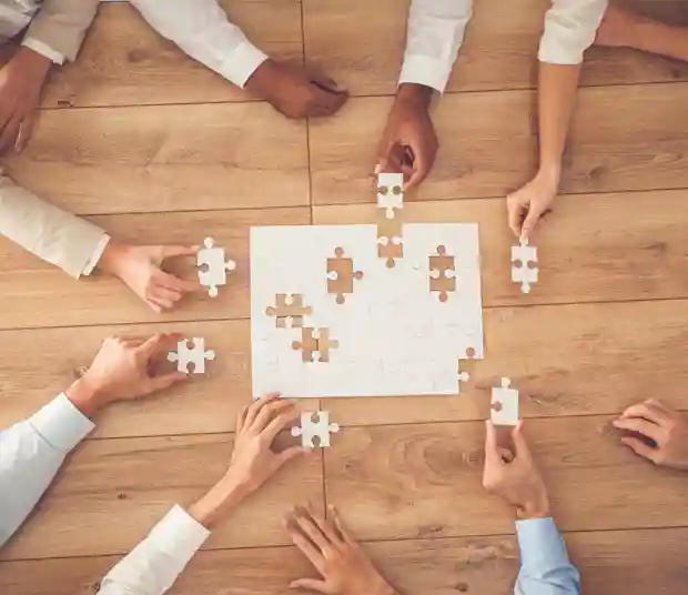 many people trying to solve a solid white puzzle